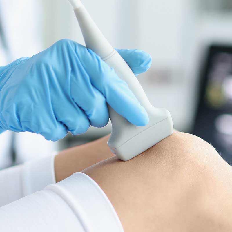 Ein Arzt untersucht mit Ultraschall ein Knie auf Anzeichen von Tendinopathie, um eine präzise Diagnose zu stellen.