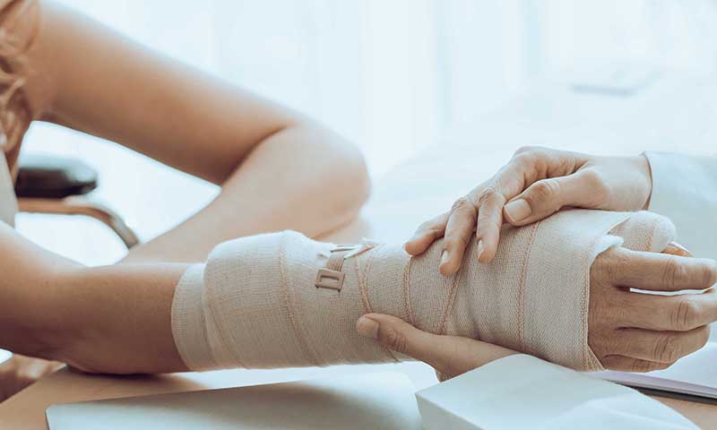 Orthopädische Untersuchung einer verletzten Hand mit Schiene nach Fraktur